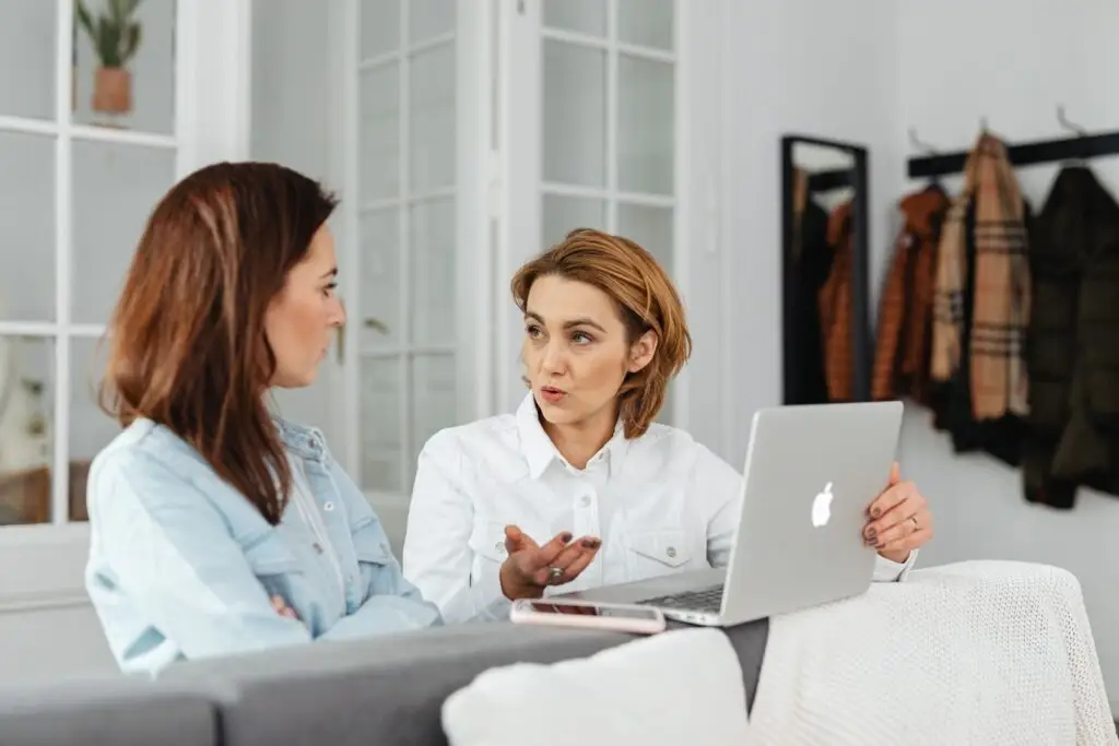 Twee vrouwen overleggen samen achter een laptop
