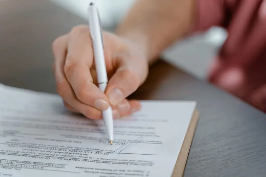 Hand ondertekent een officieel document met een pen