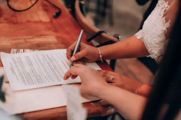 Handen ondertekenen een belangrijk document aan een houten tafel